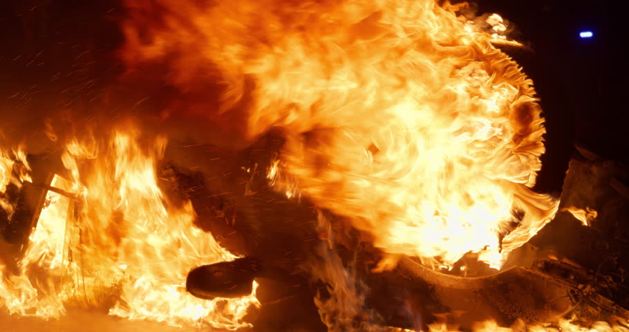 Car Accident with an Overturned Vehicle Engulfed in Flames After a Crash. Emergency Responders Arrive on the Scene, Ready to Battle Intense Fire Late at Night. Footage Without People