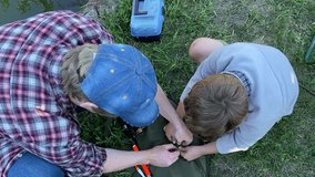 A young father and his son enjoy quality time together, fishing at a pond. The father teaches his son the basics of fishing, creating cherished memories during their outdoor family bonding experience - Powered by Shutterstock - Get 15% off with code: PIKWIZARD15