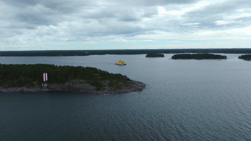 Aerial view of a yellow cable-ferry in the cloudy archipelago of Turku, Finland