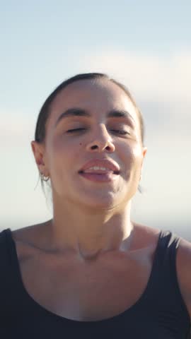 Tranquil sportswoman rejuvenating with deep breaths post-training. Athletic woman in serene repose, replenishing energy after exercise