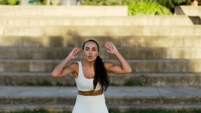Woman doing burpees outside. Sportswoman exercising in a sunny spot by the stairs - Powered by Shutterstock - Get 15% off with code: PIKWIZARD15