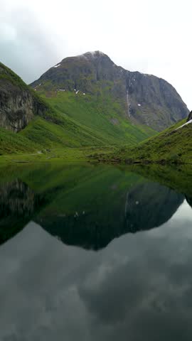 A majestic mountain reflects in a serene lake, highlighting Norway Urke region natural beauty. Its a perfect destination for nature lovers and adventurers seeking unique landscapes