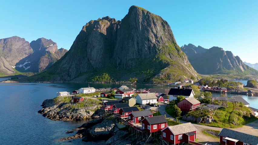 Hamnoy fishing village on Lofoten Islands Norway showcases vibrant fisherman cabins against a dramatic mountain backdrop, ideal for travel enthusiasts and adventurers