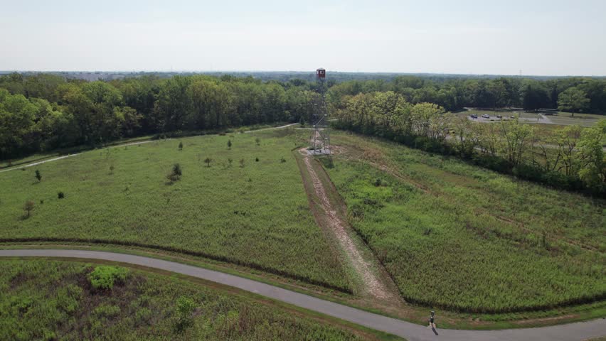 Fire tower climbing attraction in Ohio metro park near forested woods and trail outside downtown Columbus, OH made of steel looking for forest fires from drone shot and aerial view