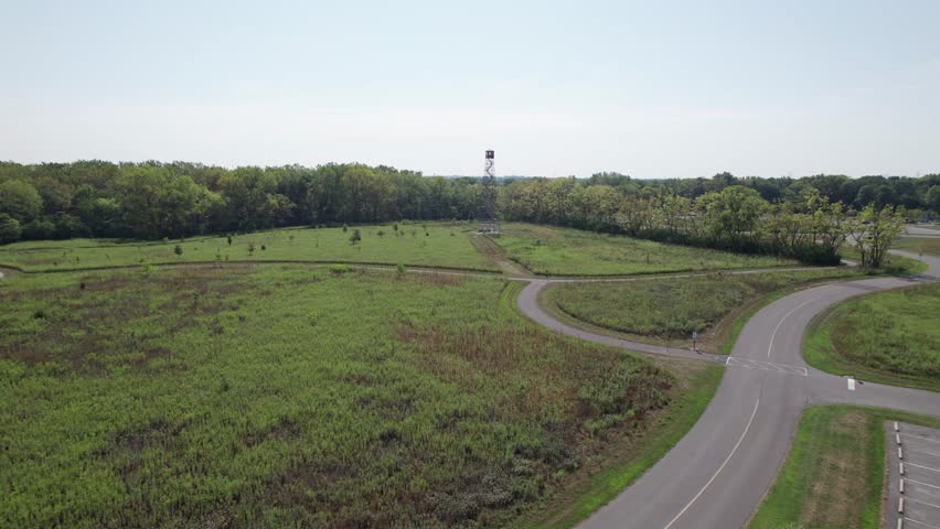 Fire tower climbing attraction in Ohio metro park near forested woods and trail outside downtown Columbus, OH made of steel looking for forest fires from drone shot and aerial view