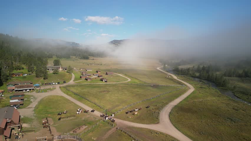 Aerial of dude ranch horse ranch hotel in Montana mountains in summer