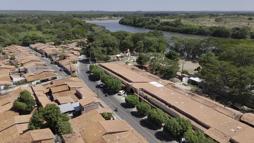 Drone flies backwards low over houses next to Poti River in Teresina, Piauí, Brazil