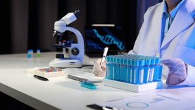 Scientists use scientific test tubes with records of chemicals or drugs being tested and examined under a microscope in a science laboratory for biology, biotechnology, medicine. - Powered by Shutterstock - Get 15% off with code: PIKWIZARD15