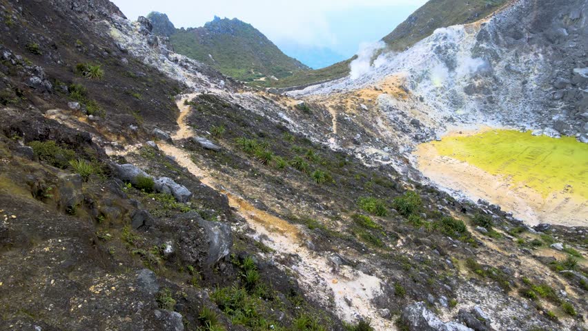 a sulfur-filled crater at the peak of a mountain with eerie beauty and vibrant yellow hues of the sulfur