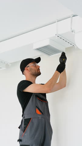 HVAC Technician Worker Testing Newly Installed Office Ventilation System. Vertical video