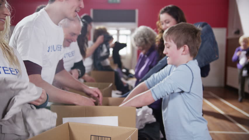 A cute young boy donates some groceries for a good cause and gets a high five from one of the volunteers. In slow motion. | Shutterstock HD Video #3583430