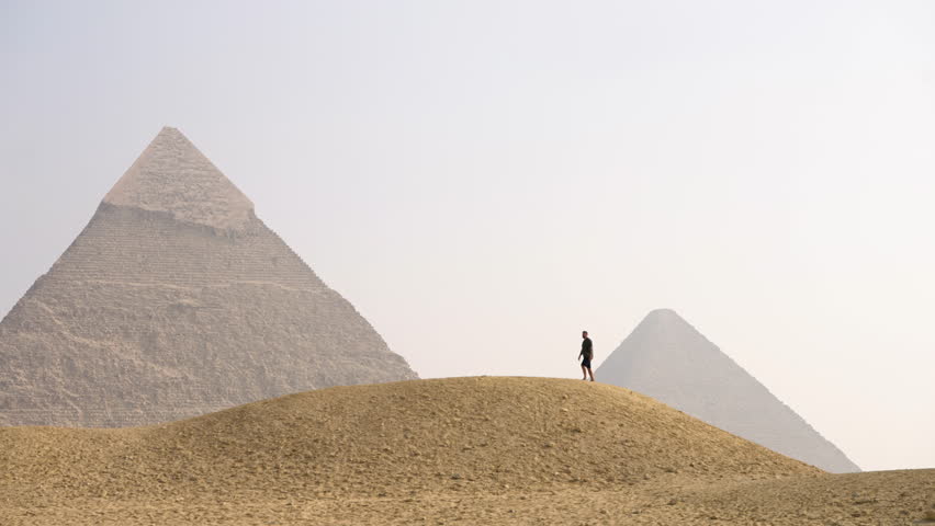 Man Isolated At The Famous Giza Plateau With Views Of Pyramids Near Cairo, Egypt. Static Shot