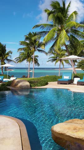 Vertical Drone Shot, Tropical Paradise Scenery, Flying Above Swimming Pool to White Sand Beach of Luxury Resort