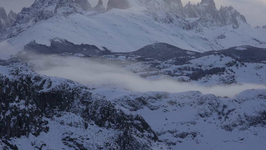 Winter landscape view of Mount Fitz Roy massif with snow covered forests in southern Patagonia. Vertical granite walls before sunset. Los Glaciares National Park, Argentina.