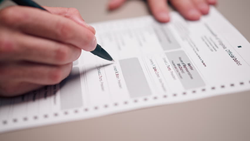 close up in the presidential election an American sample ballot a hand with a pen makes a choice with his vote deliberately spoiled ballot