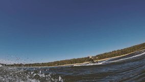 surfer girl with blond long hair dreadlocks on longboard hangs on rope behind wave boat and glides into wave in slow motion - Powered by Shutterstock - Get 15% off with code: PIKWIZARD15