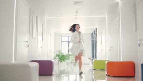 Female doctor in glasses hurrying through a modern hospital corridor to urgent surgery - Powered by Shutterstock - Get 15% off with code: PIKWIZARD15