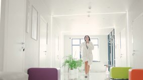 Female doctor in glasses hurrying through a modern hospital corridor to urgent surgery - Powered by Shutterstock - Get 15% off with code: PIKWIZARD15