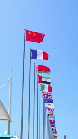 International business. Flags of many countries on the background of bright blue sky at the site of international corporation,Vertical screen