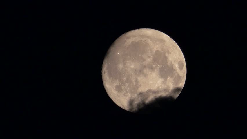 full moon disappearing among the clouds in the night sky, full moon moving among the clouds at night,