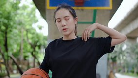 Fit young asian woman in sportswear warming up stretching her arms before a workout on an outdoor basketball court, Girl exercising outdoors. - Powered by Shutterstock - Get 15% off with code: PIKWIZARD15