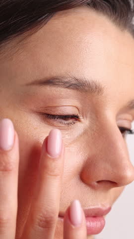 portrait of woman using natural bio product for facial care.girl with no make up,natural beauty, applying serum in palm and face, putting cream on cheeks.close up of closing eyes.smiling female