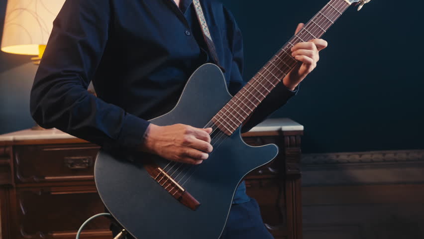 Guitar player, guitarist is performing live on stage with an electric guitar in a concert setting, music playing, live concert show, close up macro of guitar.