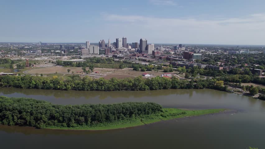 Population and capital city center of Columbus, OH, with aerial view of Scioto river, buildings, skyscrapers, business, traffic, metro parks, and Ohio people on a sunny summer day