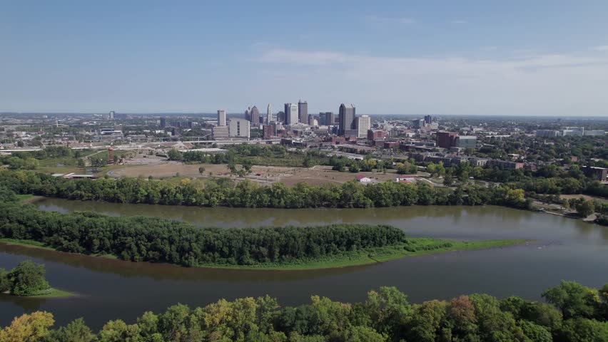 Population and capital city center of Columbus, OH, with aerial view of Scioto river, buildings, skyscrapers, business, traffic, metro parks, and Ohio people on a sunny summer day