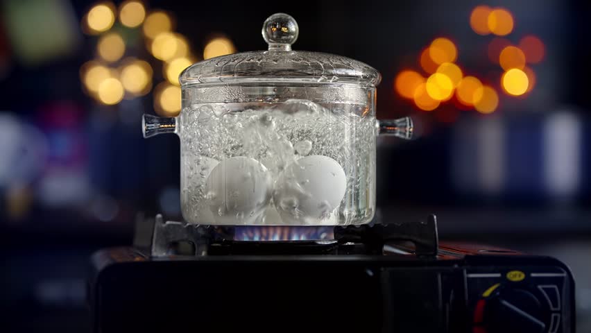 Eggs Boiling In Glass Pot For Easter. Breakfast Healthy Food. Chicken Eggs Boiled In Boiling Water On Stove. Protein Nutrition. Saucepan With Boiled Egg For Easter. Diet Breakfast Soft-Boiled Eggs Eat