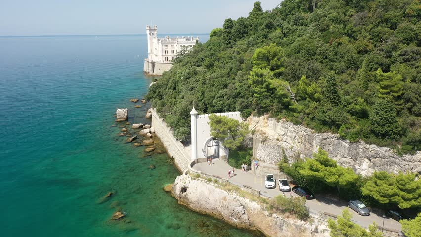 Aerial view of Miramare Castle overlooking the Adriatic Sea in Italy. A majestic summer scene captured on a sunny day.