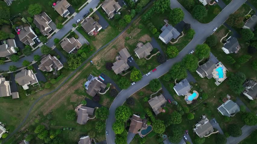 Dried out garden grass in american residential area after hot summer day. Large Property Community with swimming pool in yard. Peaceful rural landscape housing area of USA. Aerial top down flyover.