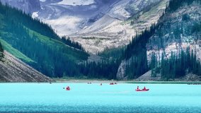 A serene view of Lake Louise, Alberta, Canada, showcases vibrant turquoise waters framed by towering, pine-covered mountains, with distant canoers paddling peacefully across the lake. - Powered by Shutterstock - Get 15% off with code: PIKWIZARD15