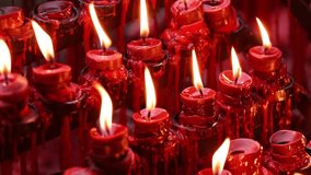 Rows of burning candles in a church or temple. Slow Motion. - Powered by Shutterstock - Get 15% off with code: PIKWIZARD15