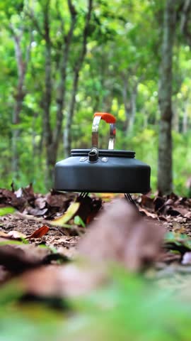 Camping kettle that is being used to cook water in the forest