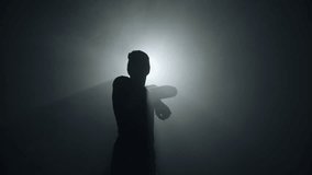 Silhouette of a talented young dancer dancing hip hop street dance on a stage in front of the spotlight - Powered by Shutterstock - Get 15% off with code: PIKWIZARD15