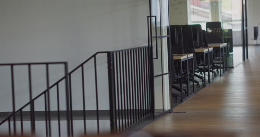 Two young business colleagues walking through a modern startup office and engaging in a dynamic discussion about various business challenges.