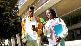 Low angle view video of male and female african american university friends using phones walking along the campus - Powered by Shutterstock - Get 15% off with code: PIKWIZARD15