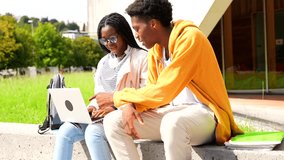 Young african american university friends using laptop sitting outside the campus in a sunny day - Powered by Shutterstock - Get 15% off with code: PIKWIZARD15