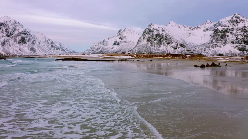 4k drone forward video (Ultra High Definition) of  Lofoten Islands. Stunning view from flying drone of Snowy mountain range. Evening seascape of Norwegian sea. Travel the world.