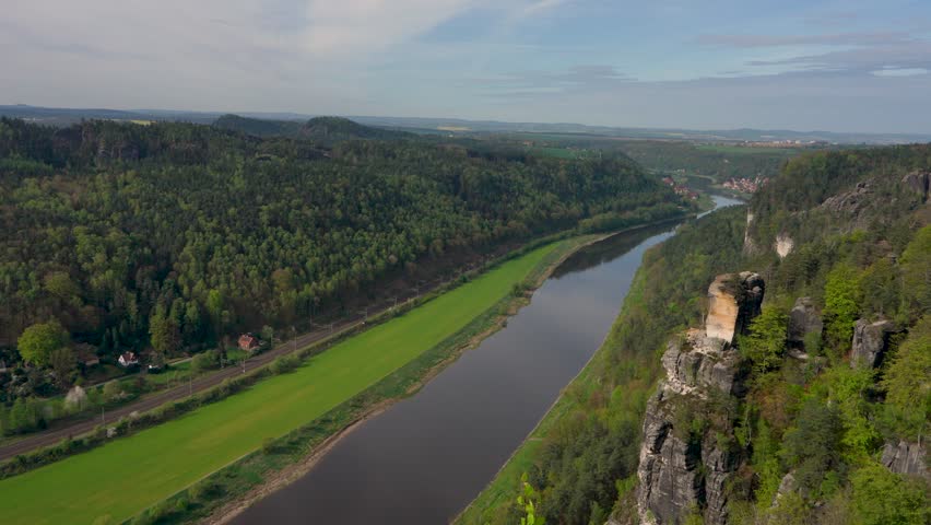 Beautiful view from  cliff overlooking  river Elbe. Small village houses. Green meadows. Saxon Switzerland, Germany