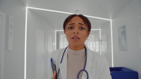 Portrait of scared medical worker running through lobby of hospital while keeping clipboard in arms. Nervous brunette doctor hurrying up into cabinet for receiving struggling sick patient. - Powered by Shutterstock - Get 15% off with code: PIKWIZARD15