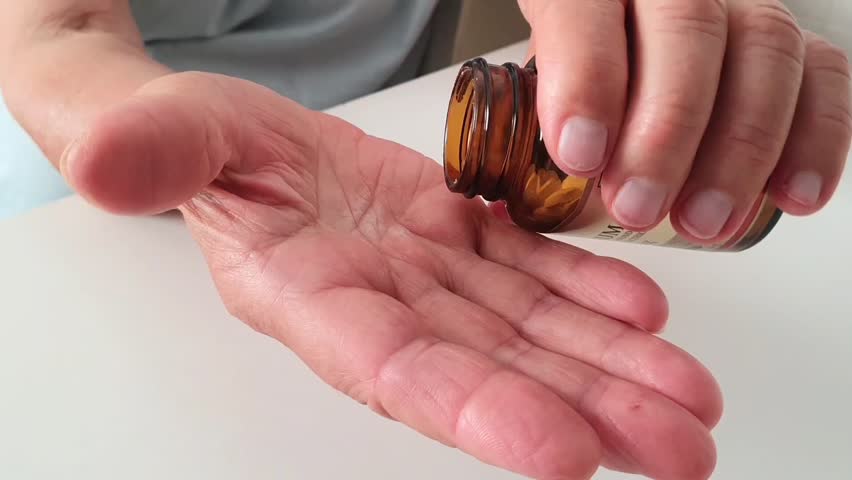 Pour tablets from the jar. Pills in hands. Taking medications, vitamins. Dosage of medications. Lots of pills. Treatment of diseases, maintaining health in old age. Diabetes, heart disease, sedatives