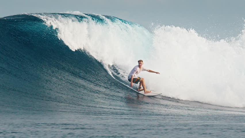 Experienced surfer rides the ocean wave at the famous Sultans surf spot on the North Atolls in the Maldives