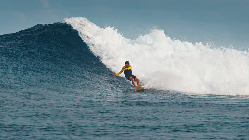 Experienced surfer rides the ocean wave at the famous Sultans surf spot on the North Atolls in the Maldives