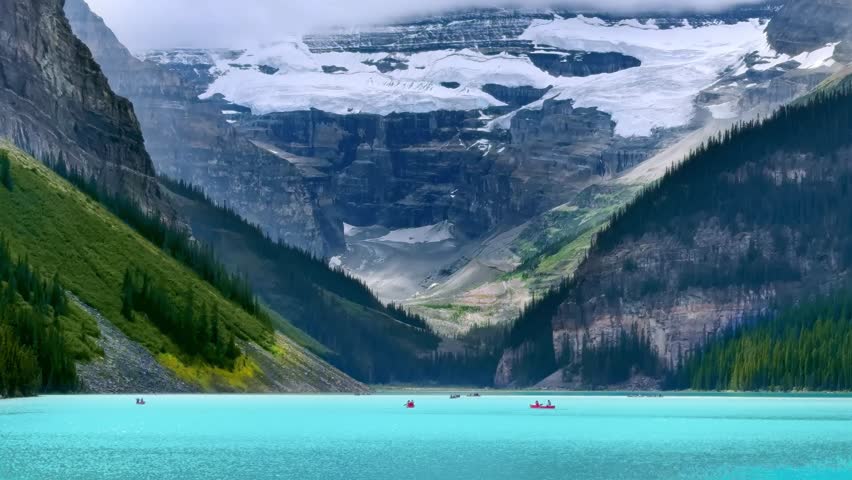 A serene turquoise Lake Louise, nestled between towering mountains, with a glacier-capped peak in the background. Small boats float peacefully on the water.
