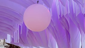 Enchanted pink orb suspended beneath flowing violet drapery at the vibrant outdoor festival in the park - Powered by Shutterstock - Get 15% off with code: PIKWIZARD15