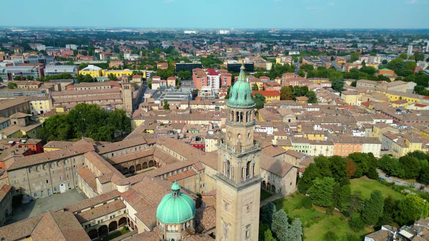 An aerial view of Parma, Italy, showcasing the iconic Cattedrale di Parma and the Battistero di Parma, captured by a drone.  This historic city is known for its rich cultural heritage