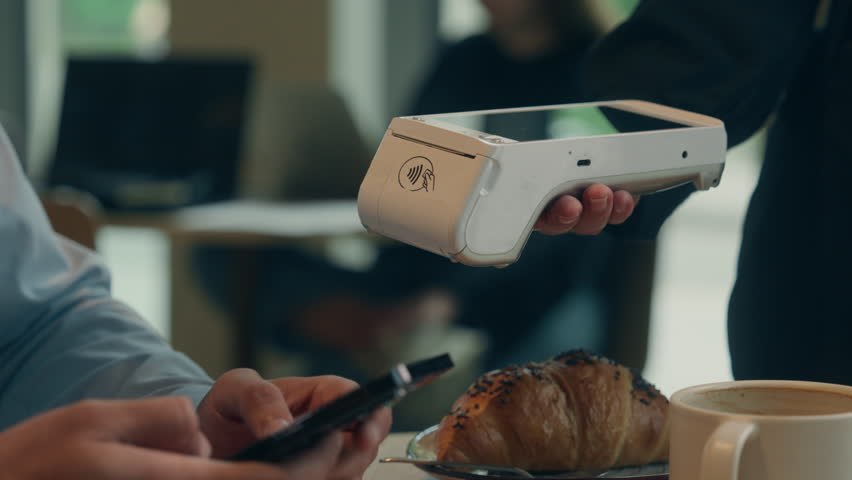 Close up hands visitor man pay bill food order in cafe restaurant unrecognizable waiter holding terminal wifi scan using smartphone contactless NFC payment cashless client service mobile phone bank