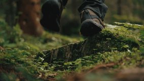 Close up gimbal shot of male hiker walking along path in rainy mountain forest, foot steps on stones covered with green moss. Man trekking in woodland. Slow motion steady shot - Powered by Shutterstock - Get 15% off with code: PIKWIZARD15